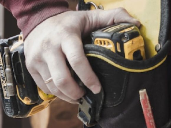 Trader's hand on a power tool.