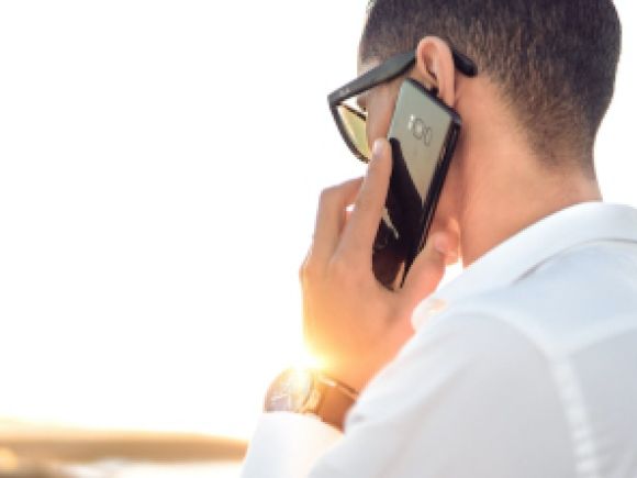 Man in a white shirt making a phone call