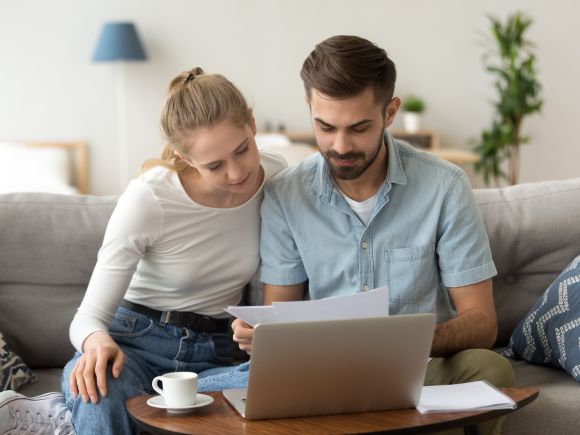 Young couple holding reading rent documents - Platform Rent Review 2025