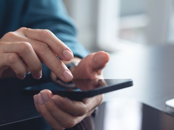 Man using a mobile phone pressing an app