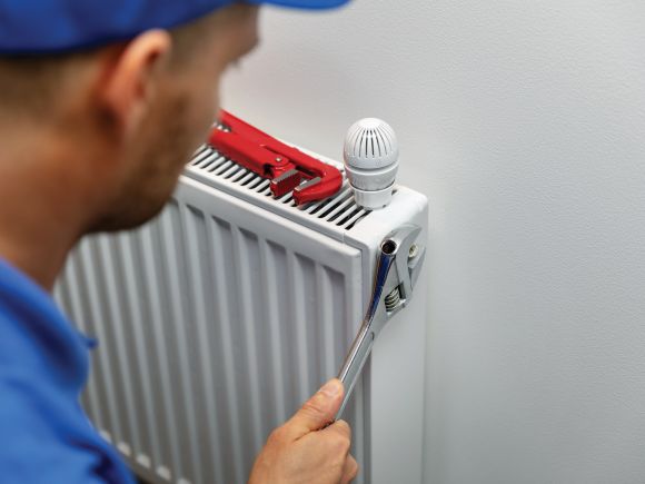 Engineer Fixing a Radiator