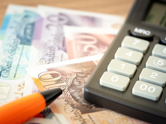 Image of money and a calculator, checking money and benefits