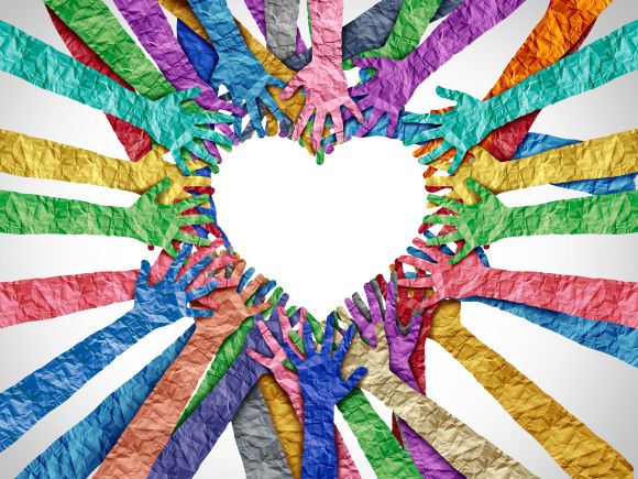 Group of multicoloured paper hands making the shape of a heart
