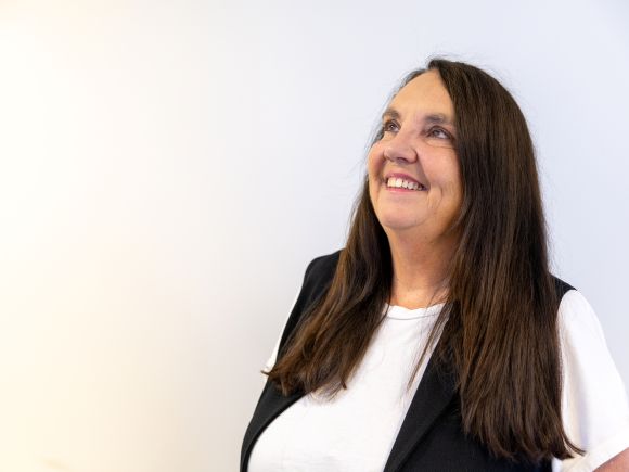 Female staff member looking up to the left and smiling.