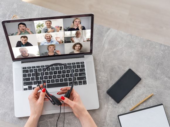 Person joining an online video call with nine images of other attendees on their screen