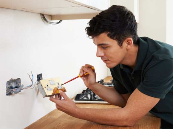 Electrician Installing a new socket in a kitchen 