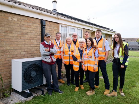 Group of Platform and Equans staff with a Air Source Heat Pump at a bungalow in Chapel St Leonards