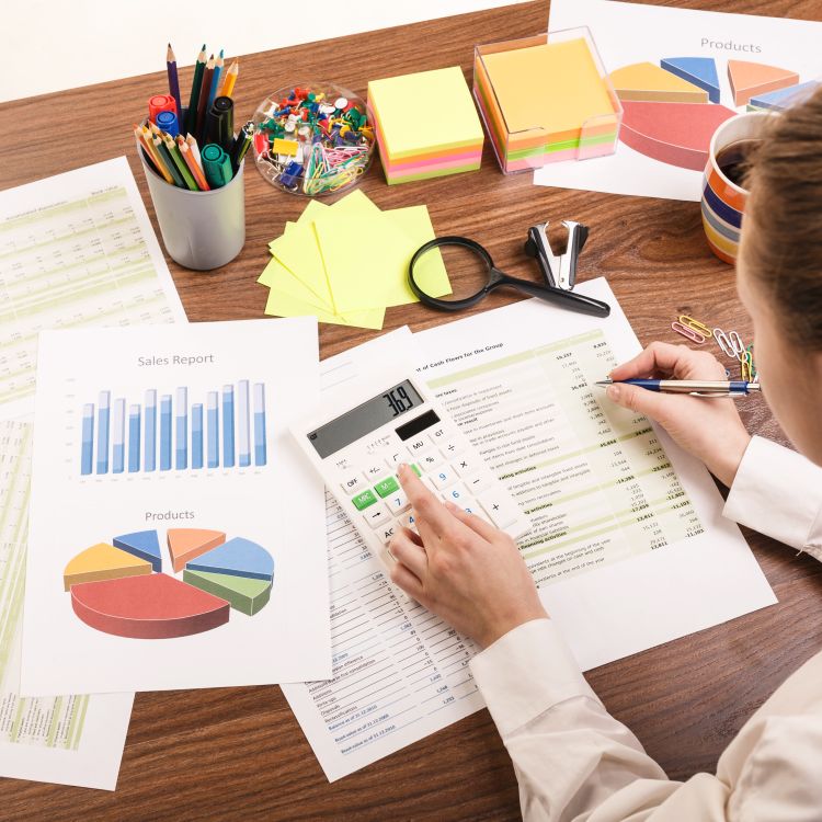 Woman with calculator and graph reports