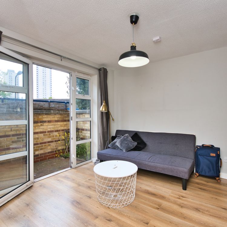 An empty furnished living room with open bifold doors - Ending a tenancy on behalf of someone else