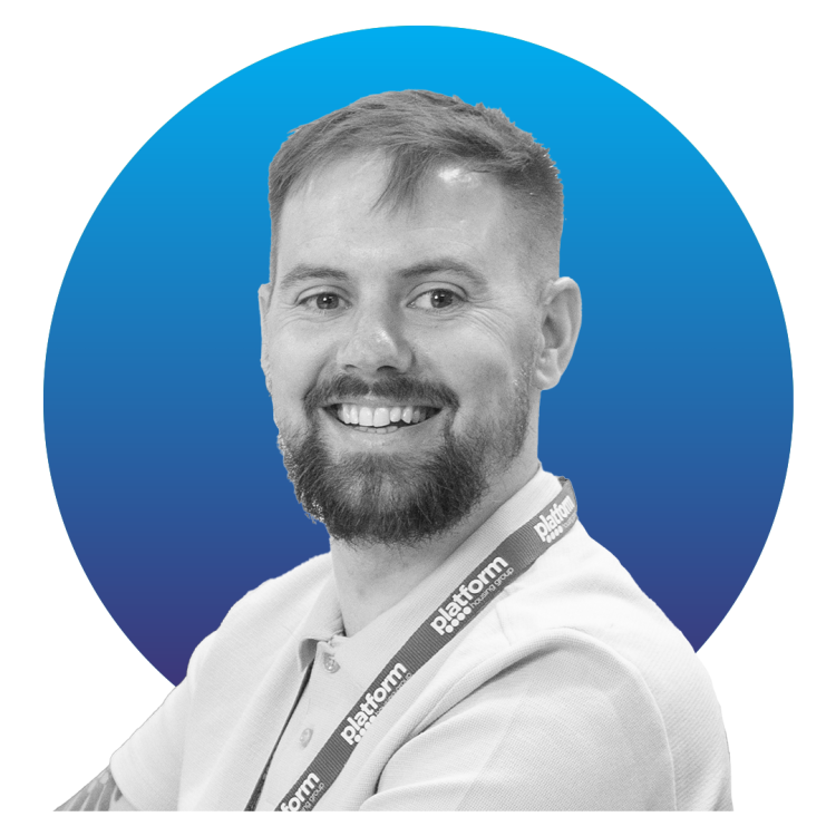 Black and white image of a man in a white shirt sat in front of a blue circle