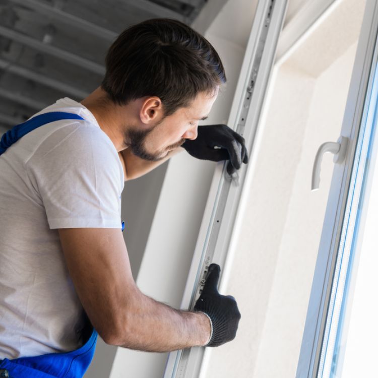 A tradesman installing a new window frame in a property
