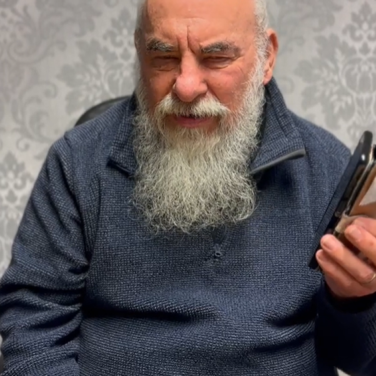 Image of Alan, wearing a blue jumper and holding a phone in his left hand calling Platform Housing Group