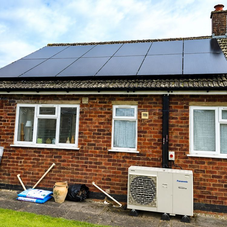 Solar panels and an air source heat pump installed at a red-brick bungalow as part of energy efficiency improvements.