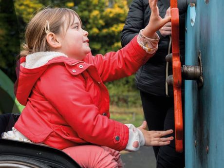 Young girl in wheelchair playing at the park