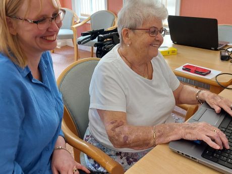 A lady being supported and helped to get online