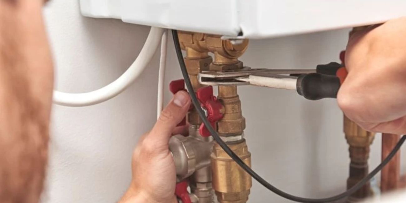 Repairs satisfaction - engineer fixing a pipe on a boilder