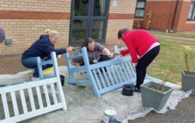 Colleagues restoring a bench