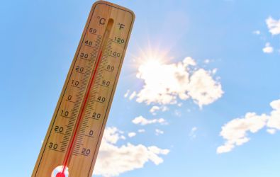 Wooden outdoor thermometer background scorching summer sun and blue sky